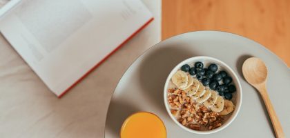 Top view of healthy breakfast with oatmeal, fresh fruit, and orange juice on a tray.