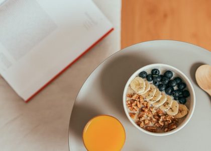 Top view of healthy breakfast with oatmeal, fresh fruit, and orange juice on a tray.