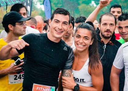 Group of runners smiling in the rain during a marathon race event.